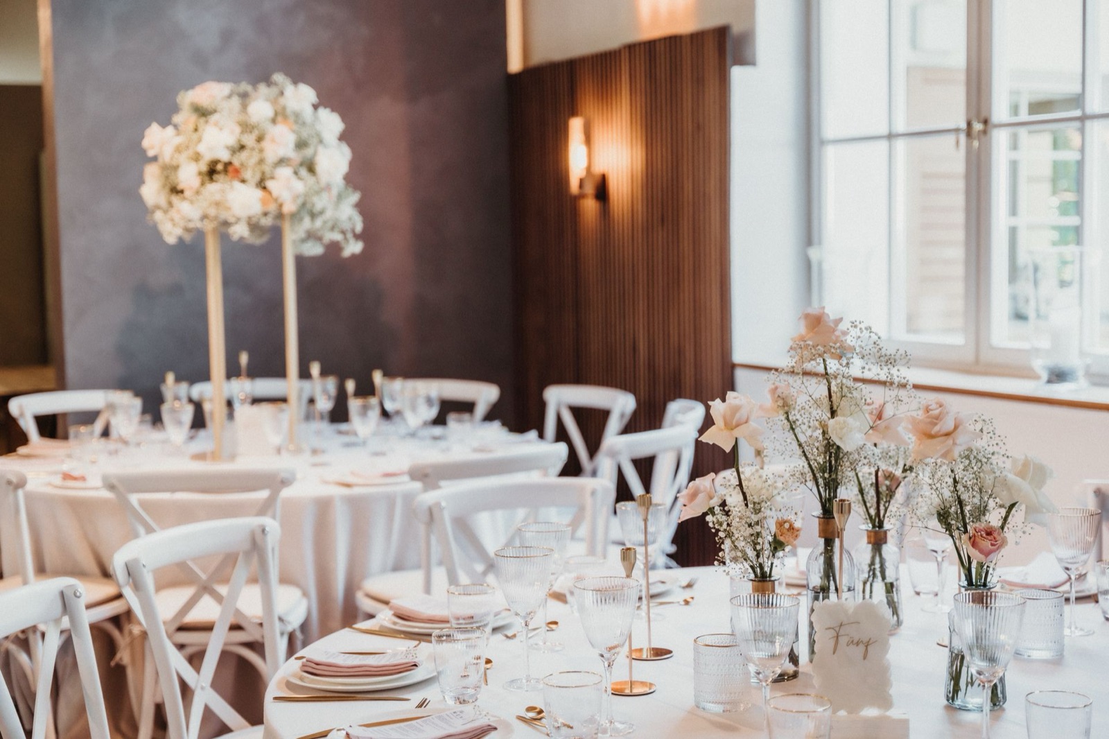 Wedding reception tables dressed with flowers at a venue