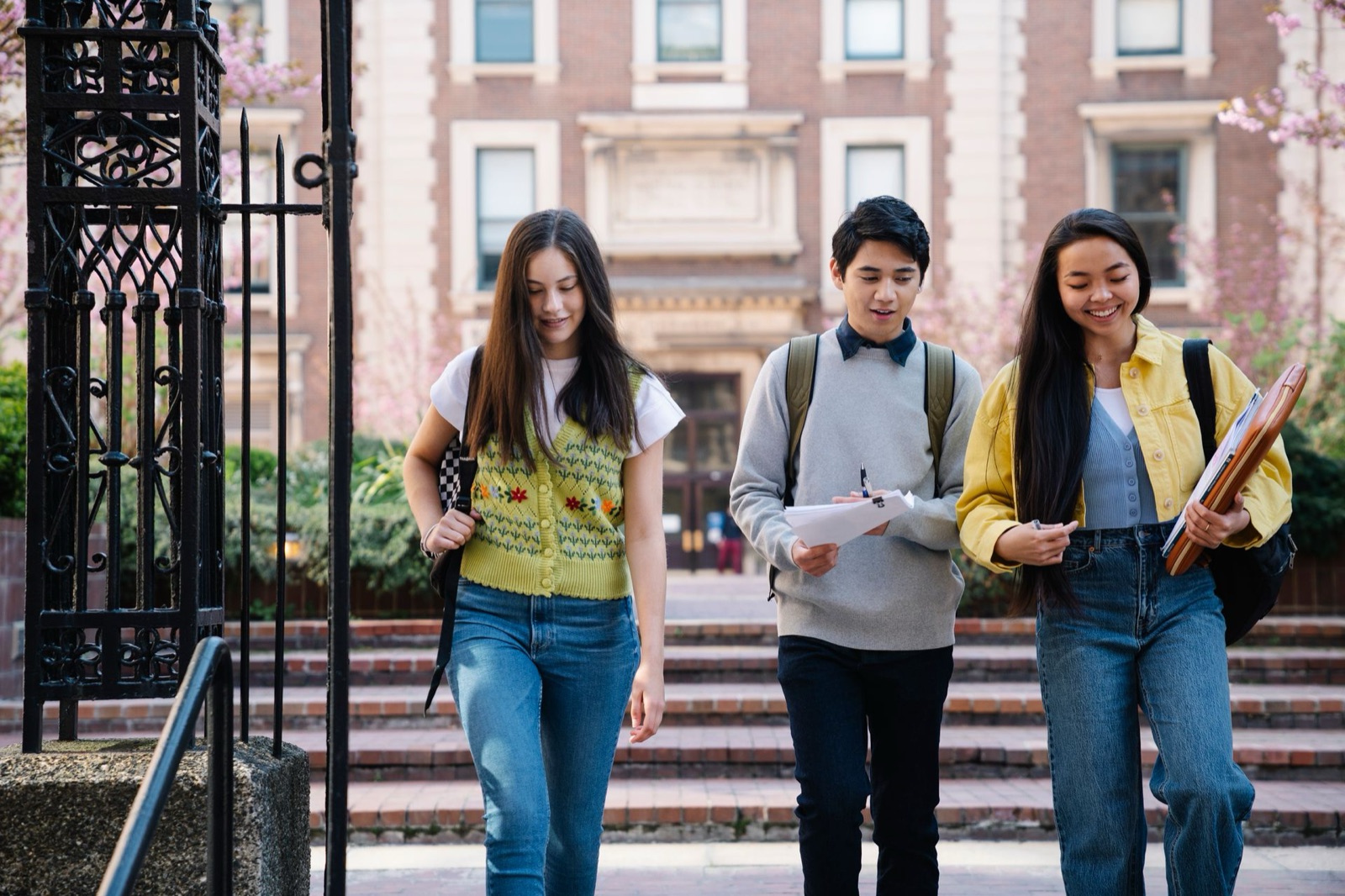 Three students walking out of a campus gate