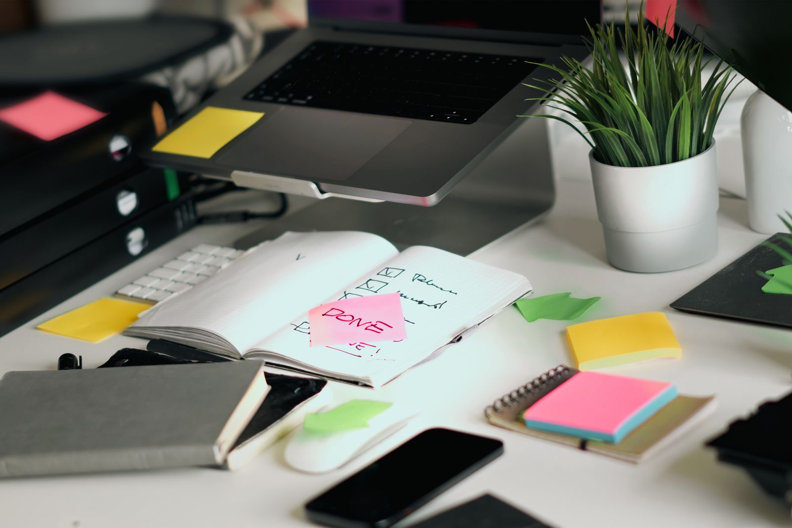 A planner and phone open on a desk while scheduling posts