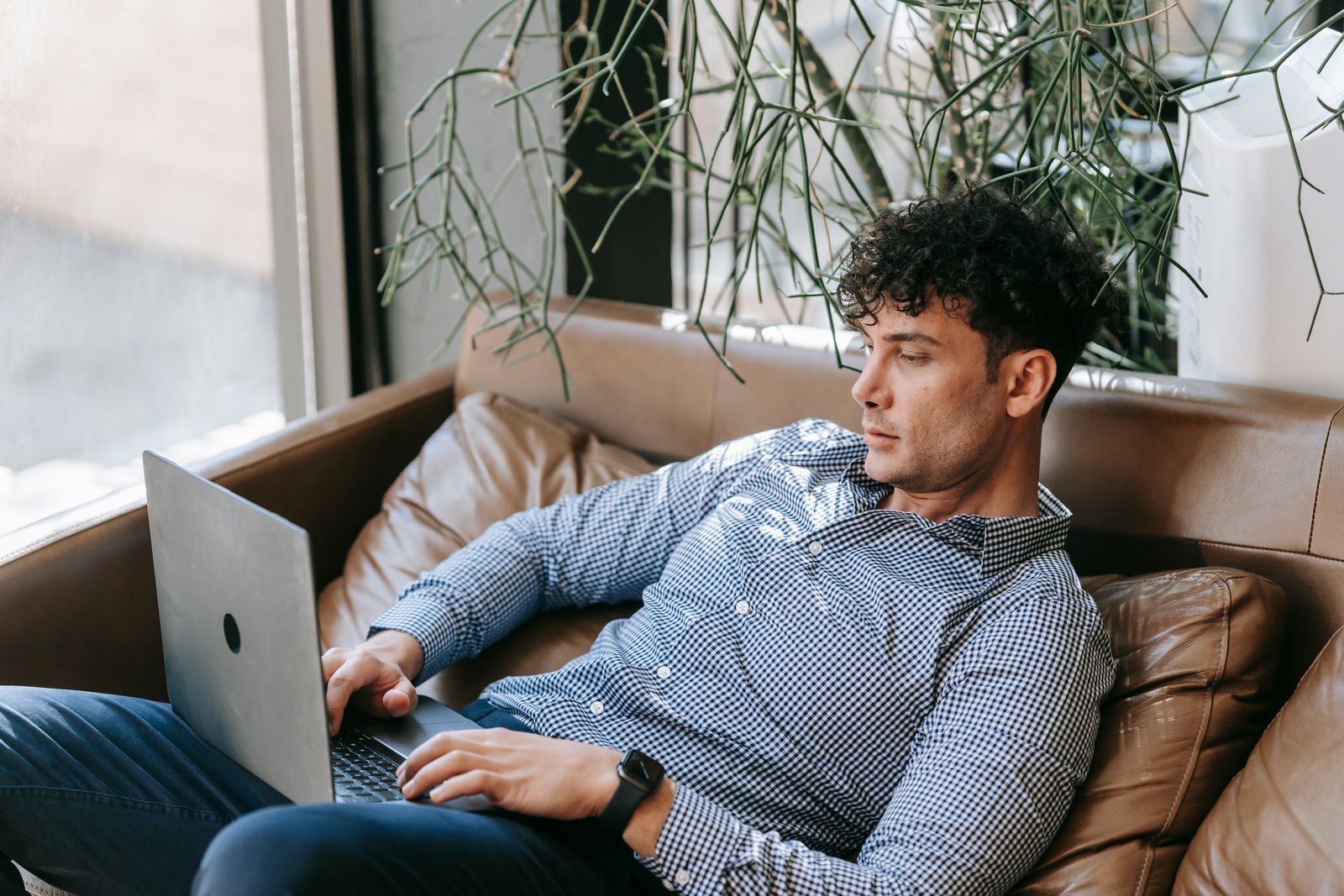 A man working on a laptop from a couch