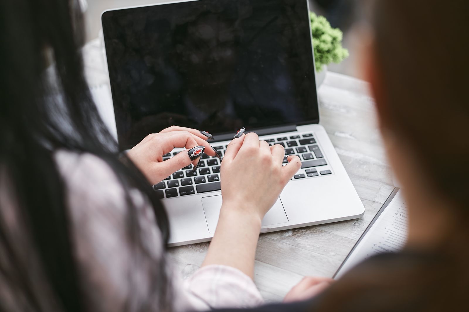 Hands working through website results on a laptop