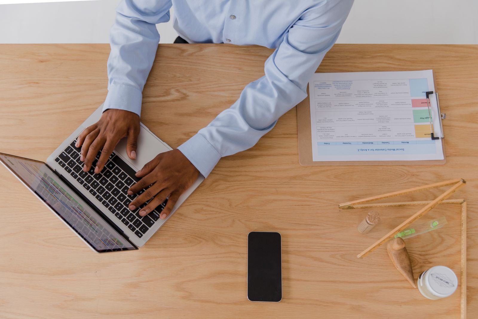 A business owner working at a laptop with a phone and notes beside it