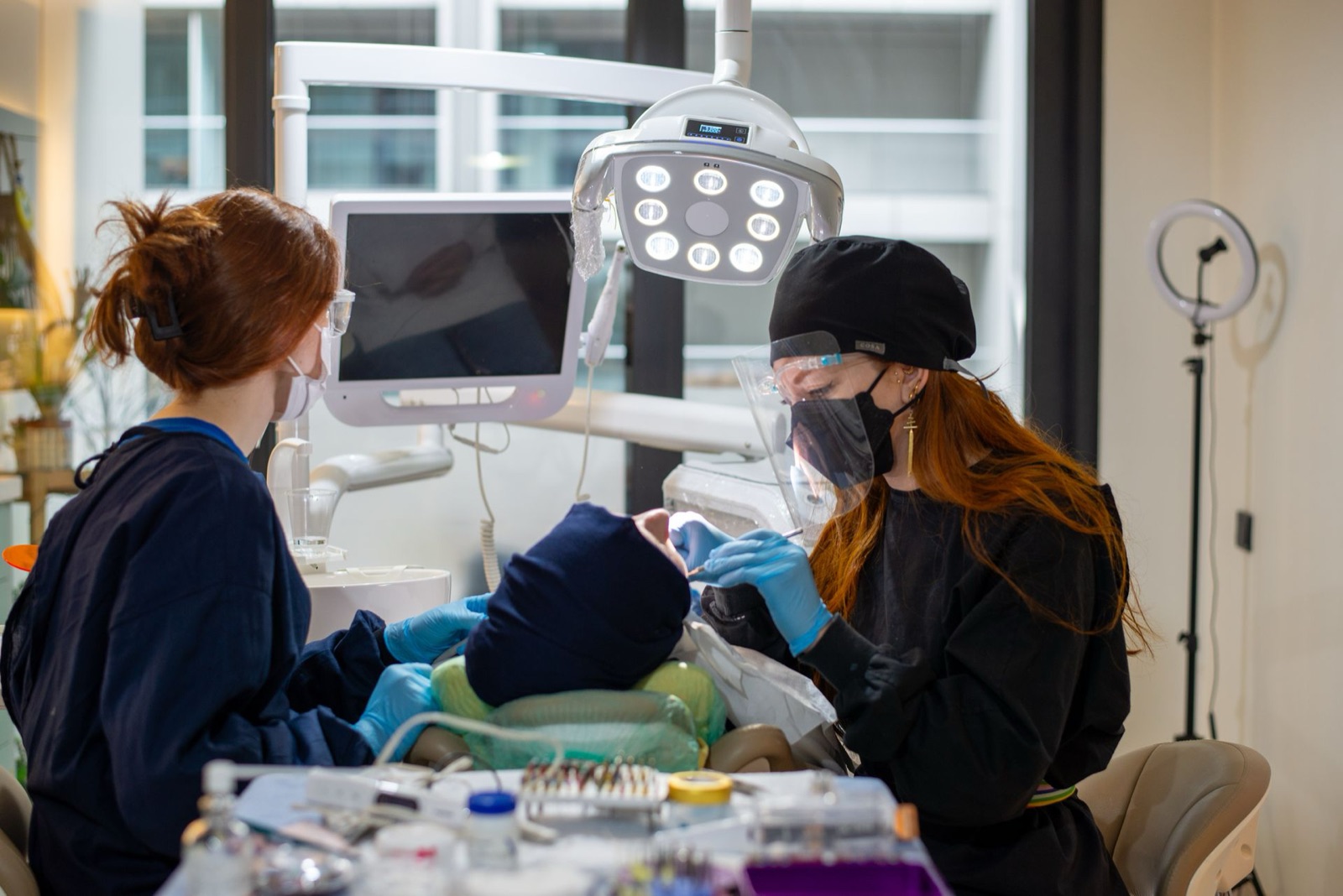 Two dental professionals treating a patient in a modern clinic