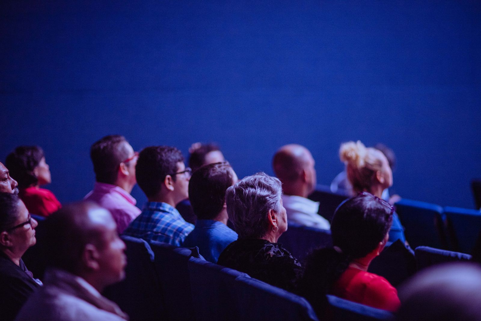 An audience watching a speaker at a conference