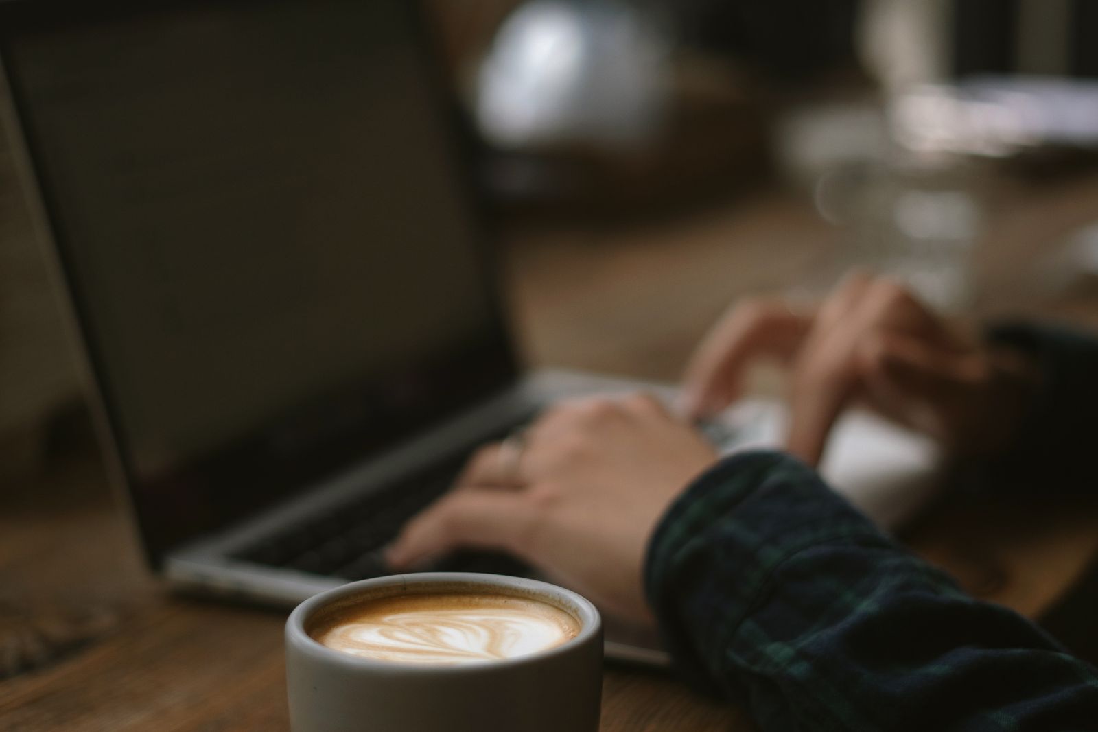 Close-up of Person Working on Laptop Drinking Coffee