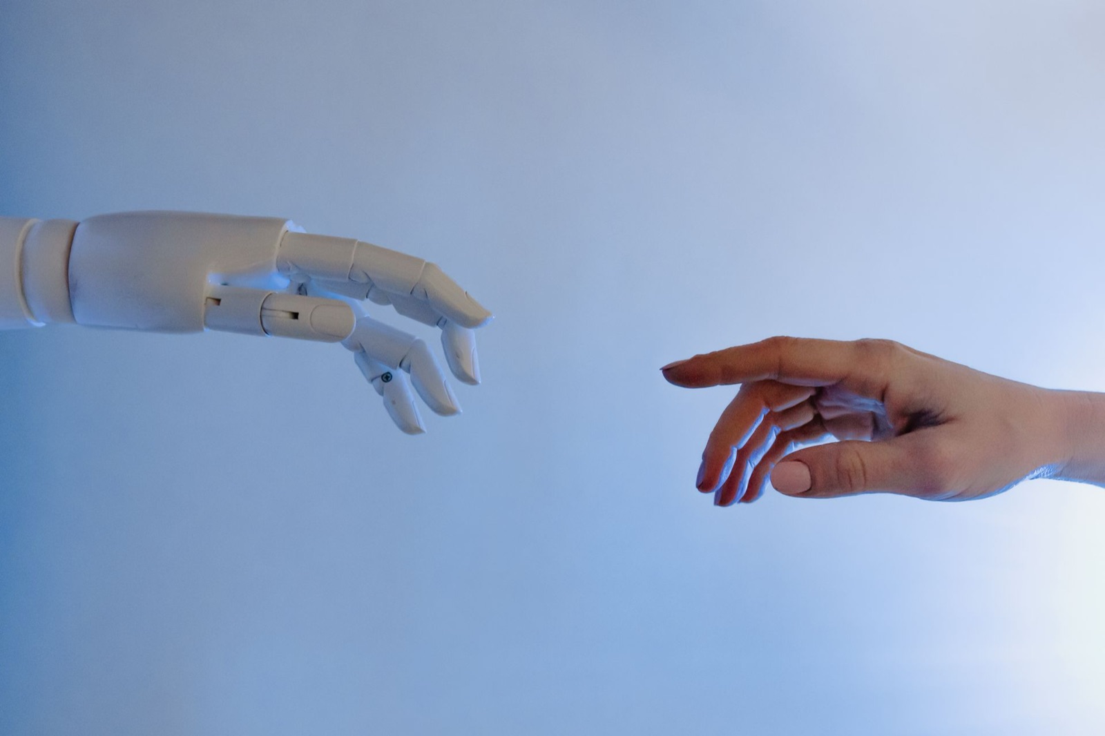A human hand and a robotic hand reaching toward each other