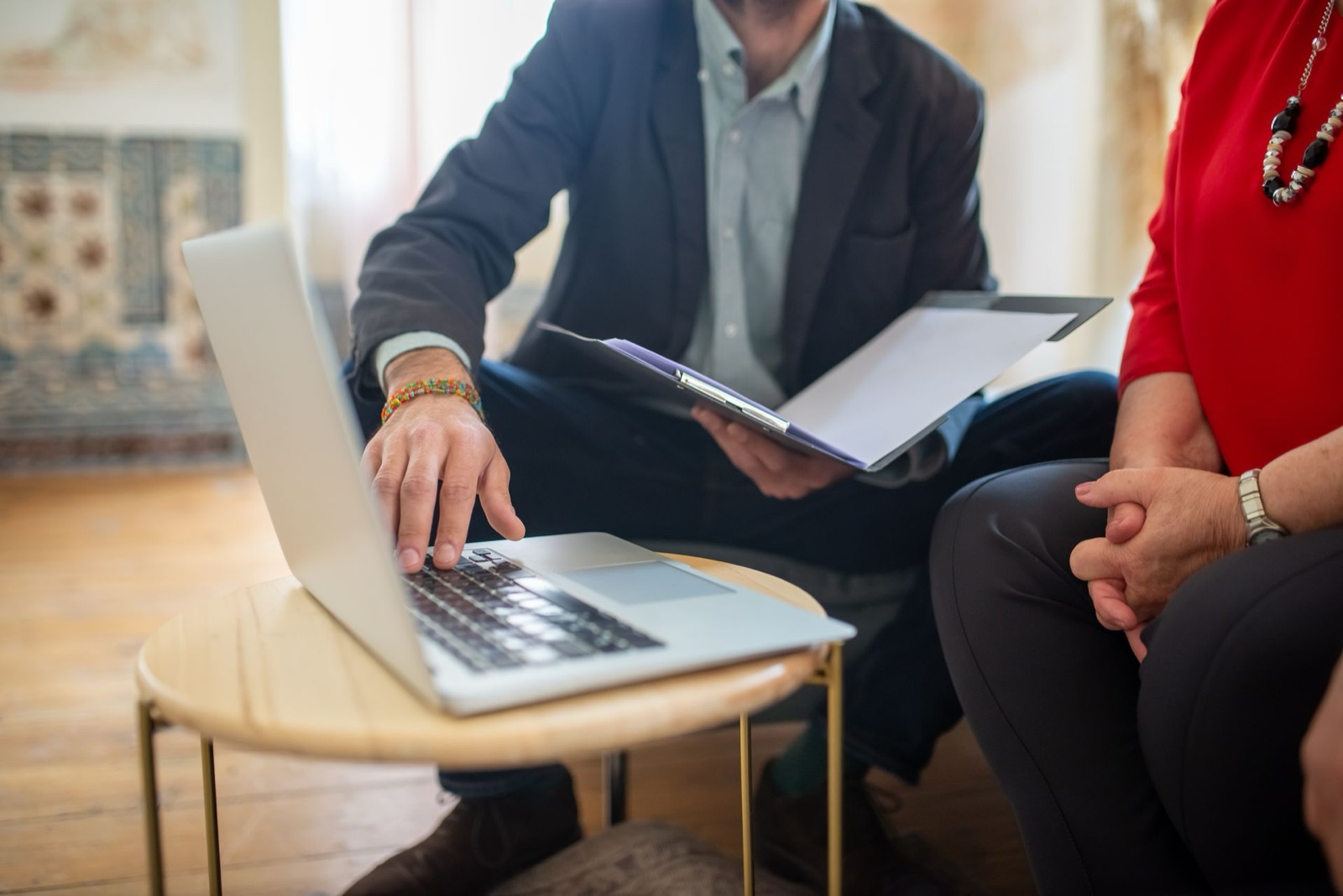 An attorney reviewing documents with a client next to a laptop