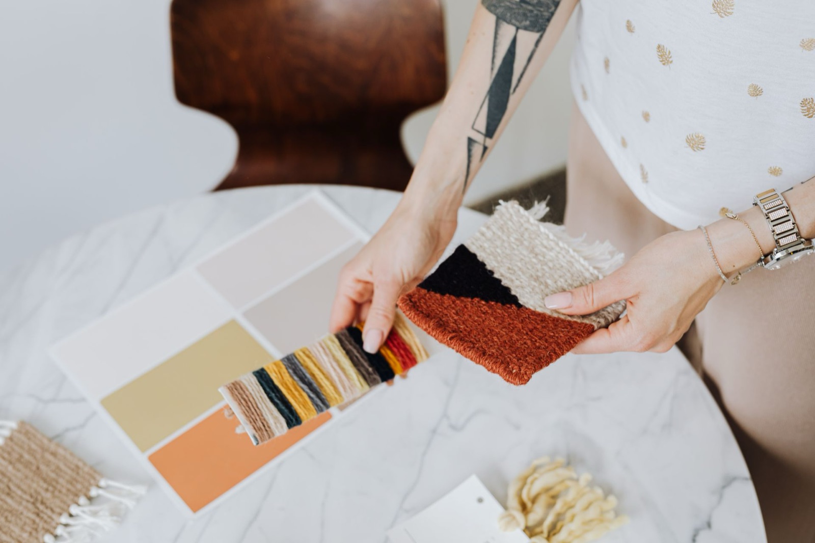 A designer comparing fabric and color samples at a table