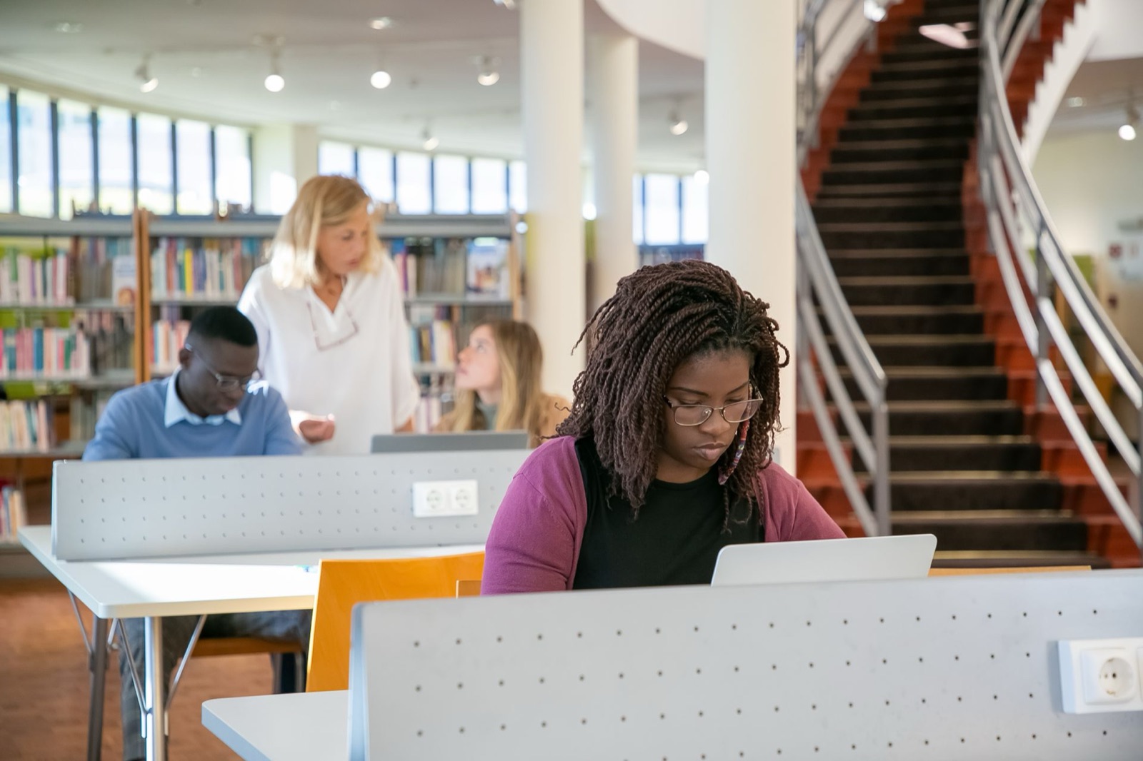 A student researching on a laptop in a university library