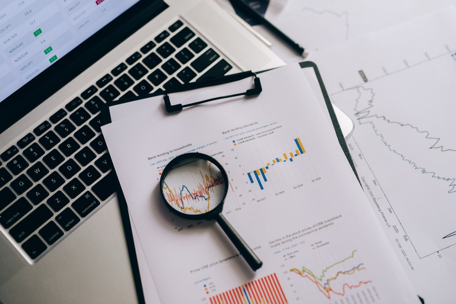 A magnifying glass over printed marketing charts