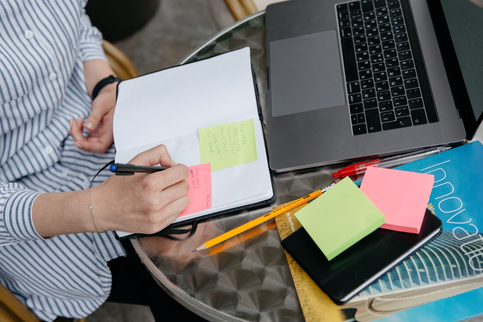 A marketer working out a brand persona in a notebook beside a laptop