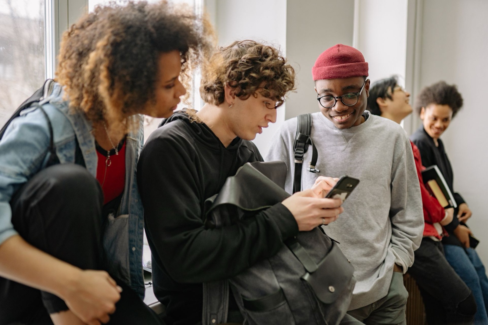 College students looking at a smartphone together between classes