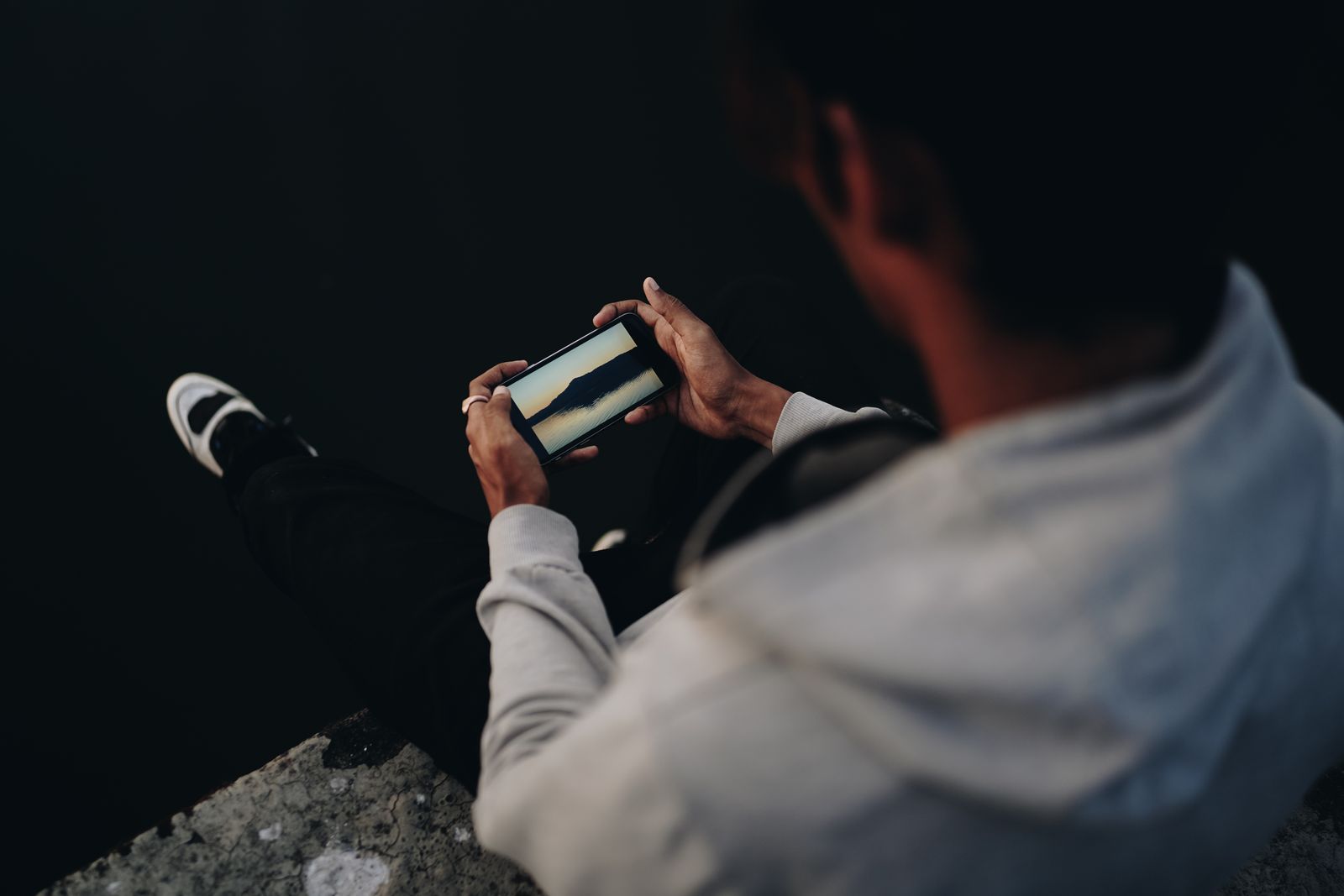 A person scrolling on a phone at night