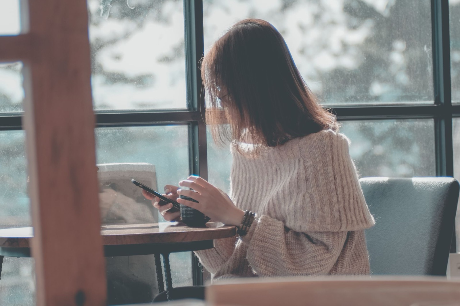 A person searching on their phone inside a local cafe