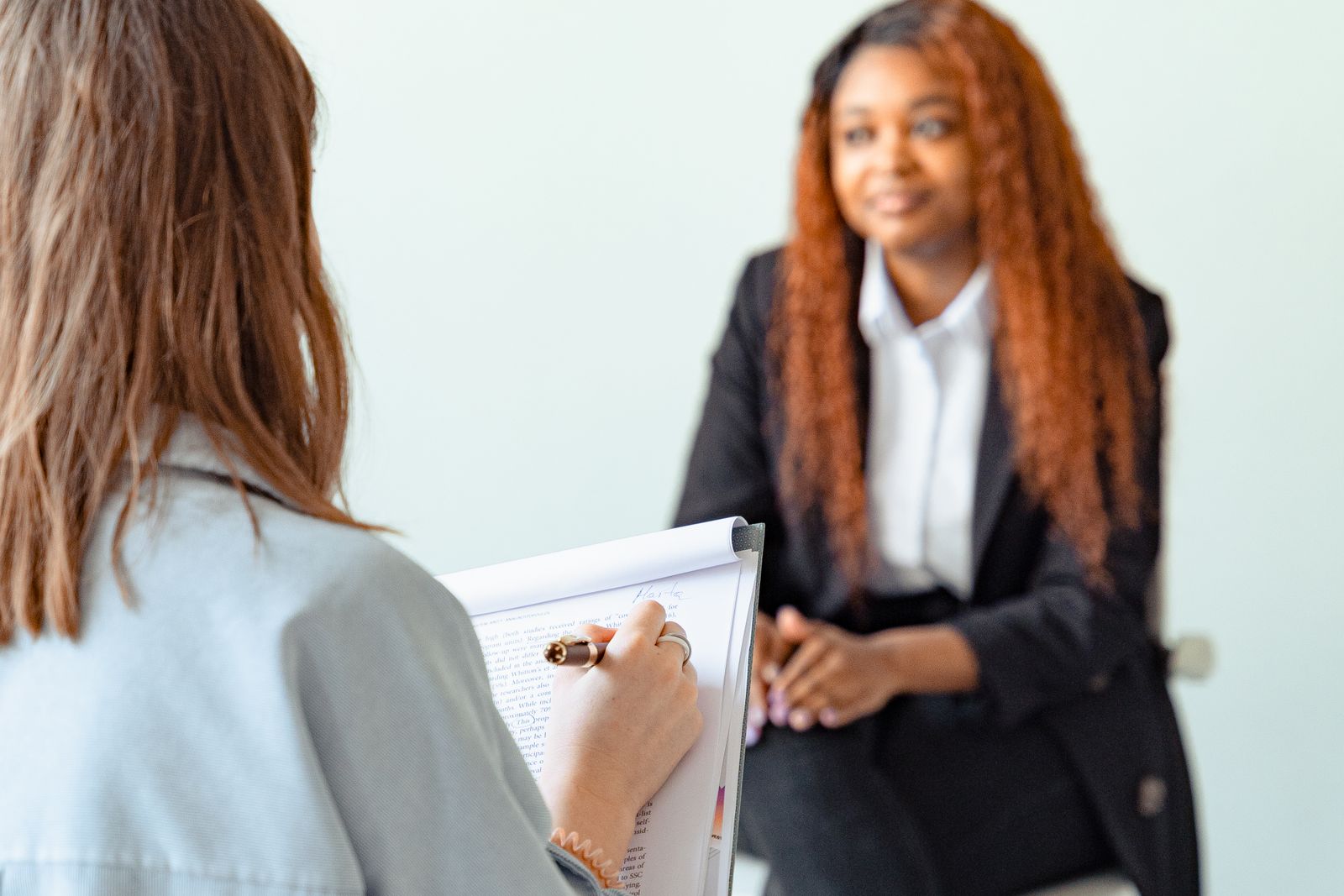 A Woman in Checkered Suit Conducting an Interview