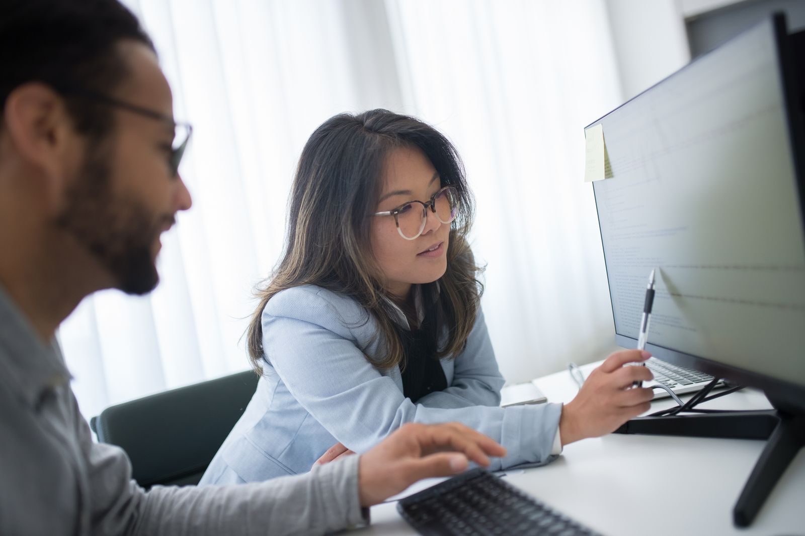Two creatives pointing at a monitor while refining brand imagery