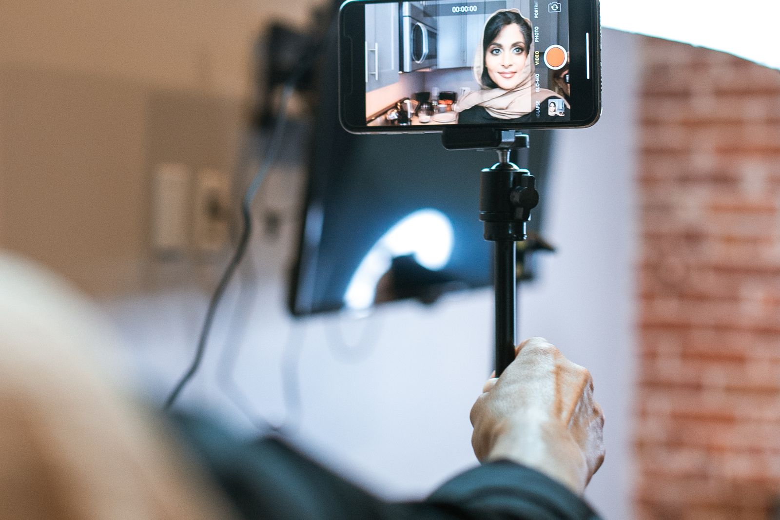 A content creator filming herself with a phone at home