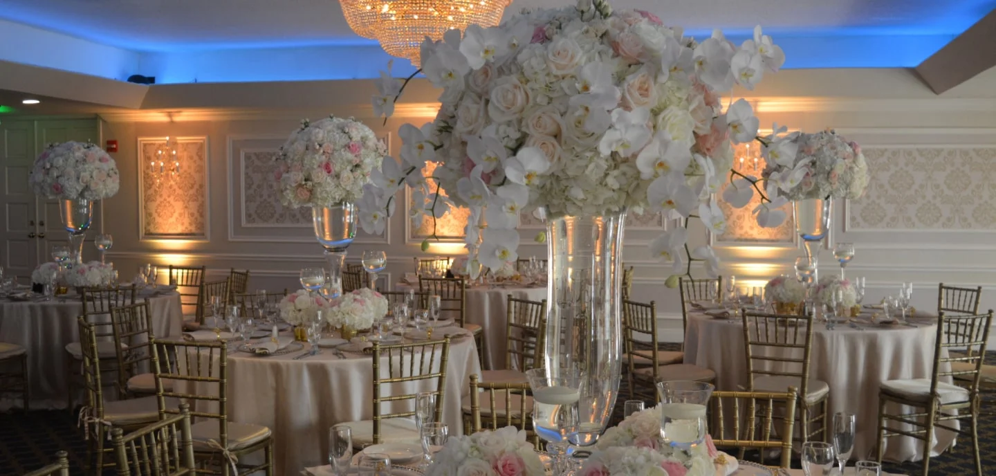 A Grand Salon ballroom in Miami dressed for a wedding reception, with floral centerpieces and gold chairs