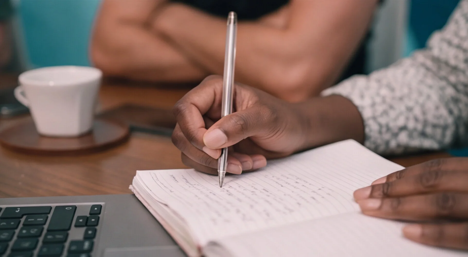 A Pacific54 strategist taking notes next to a laptop during a working session